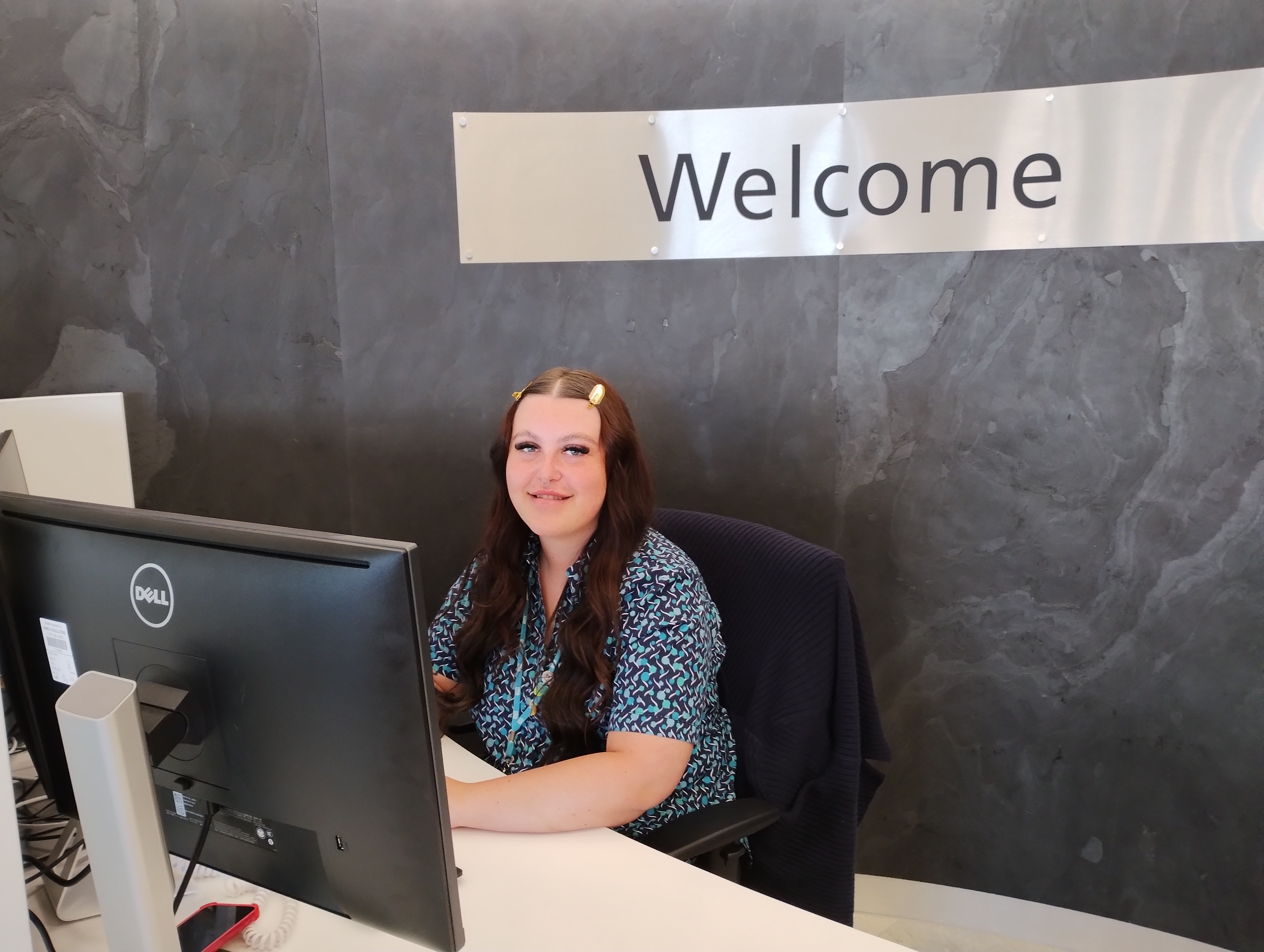 Picture of smiling receptionist sitting at the diagnostic centre's reception desk