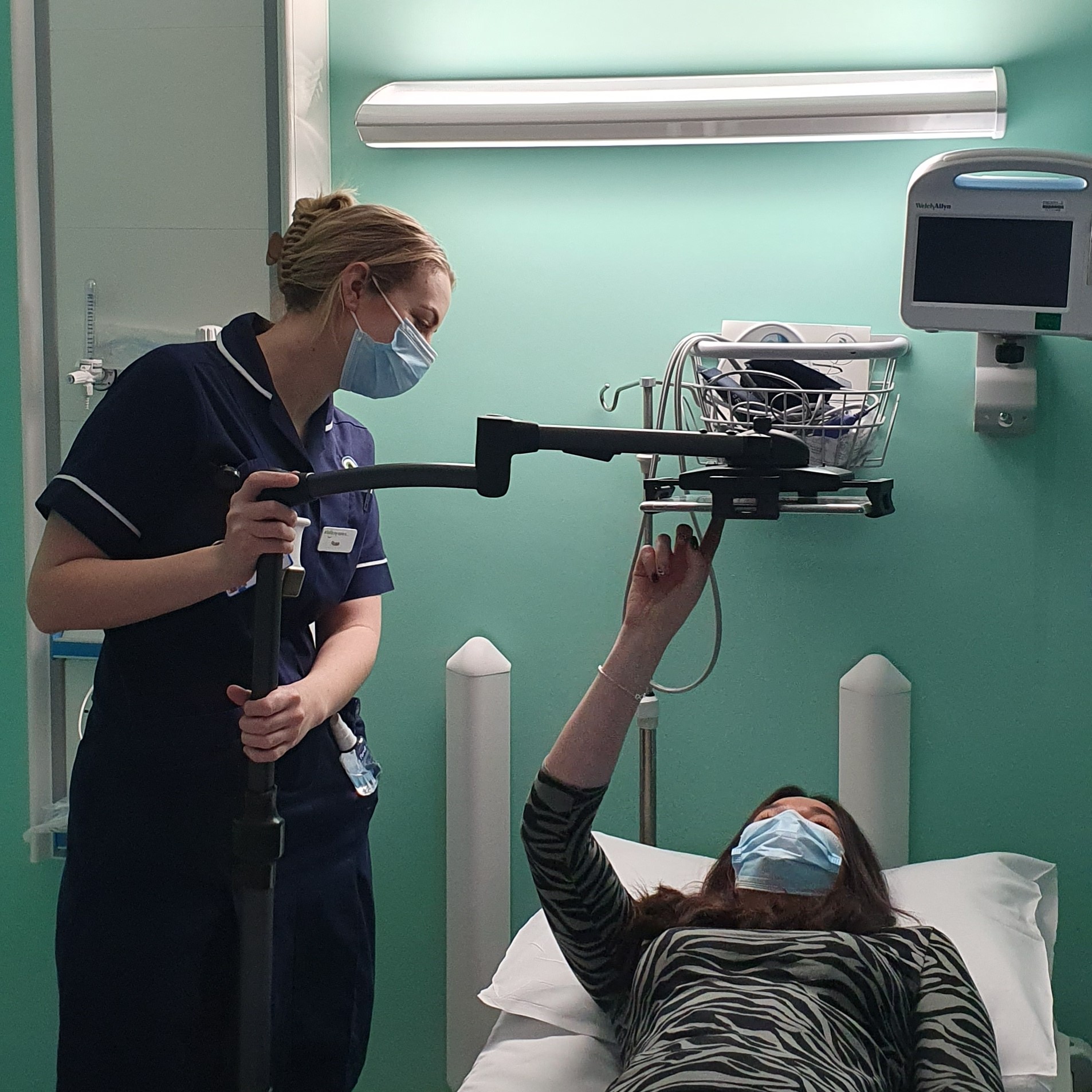 A nurse helps a patient to use the new digital equipment stand