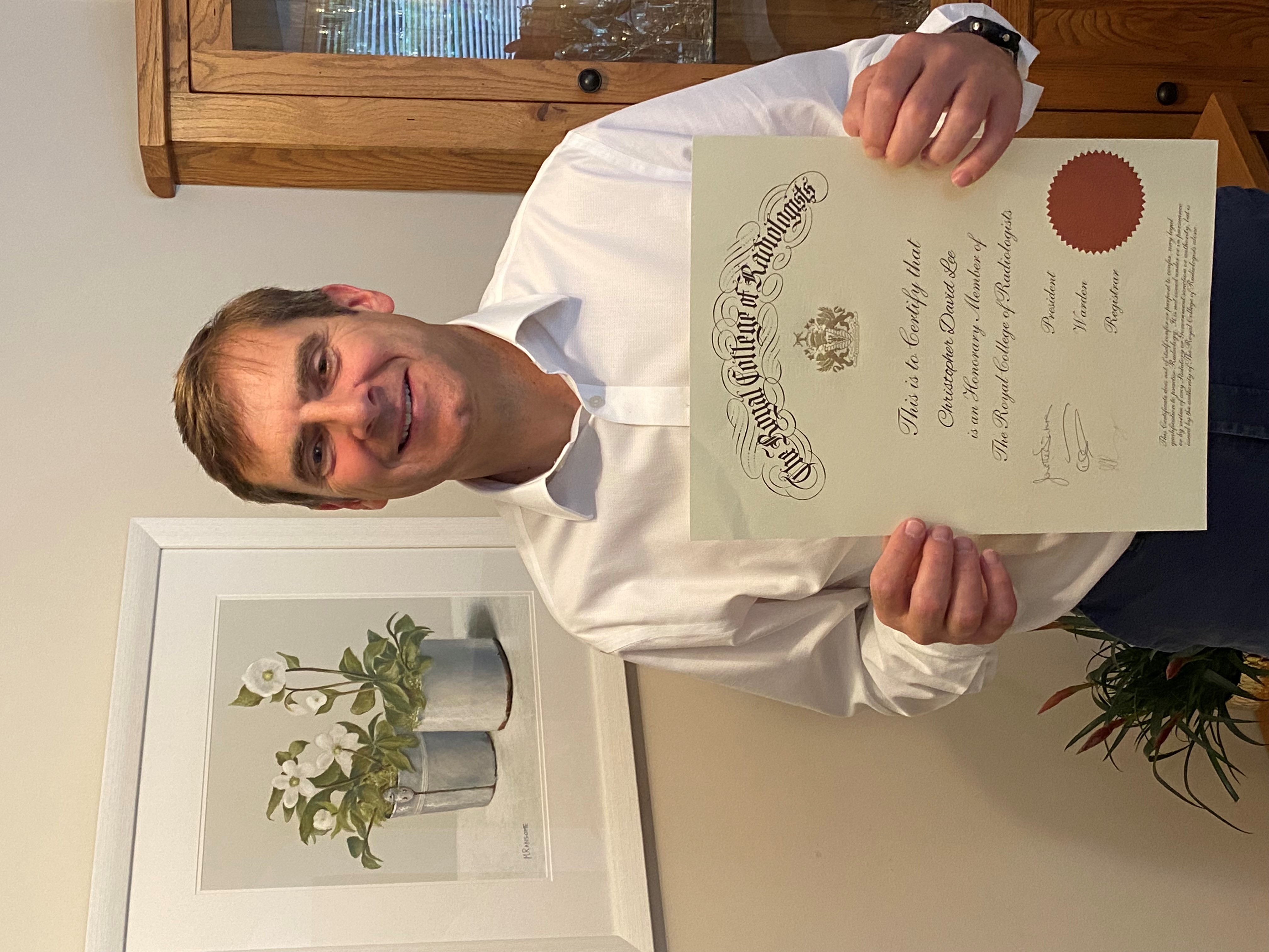 Chris Lee with a copy of his certificate from the Royal College of Radiologists