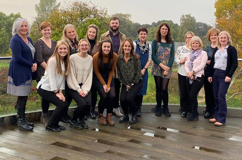 Picture of speech and language therapy team smiling. They are pictured outside. 