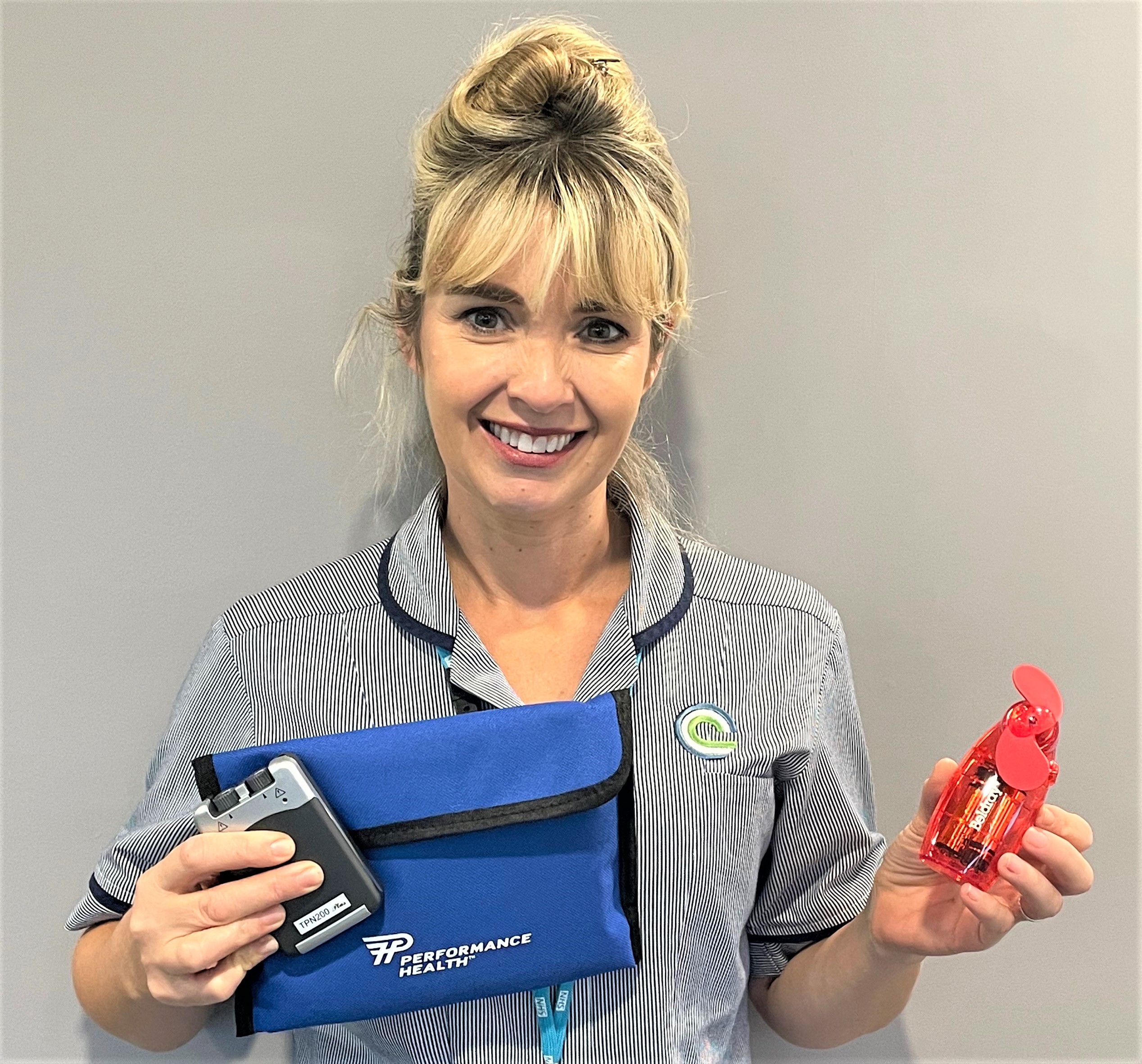 Clatterbridge nurse Emma Davey with a TENs machine and handheld fan